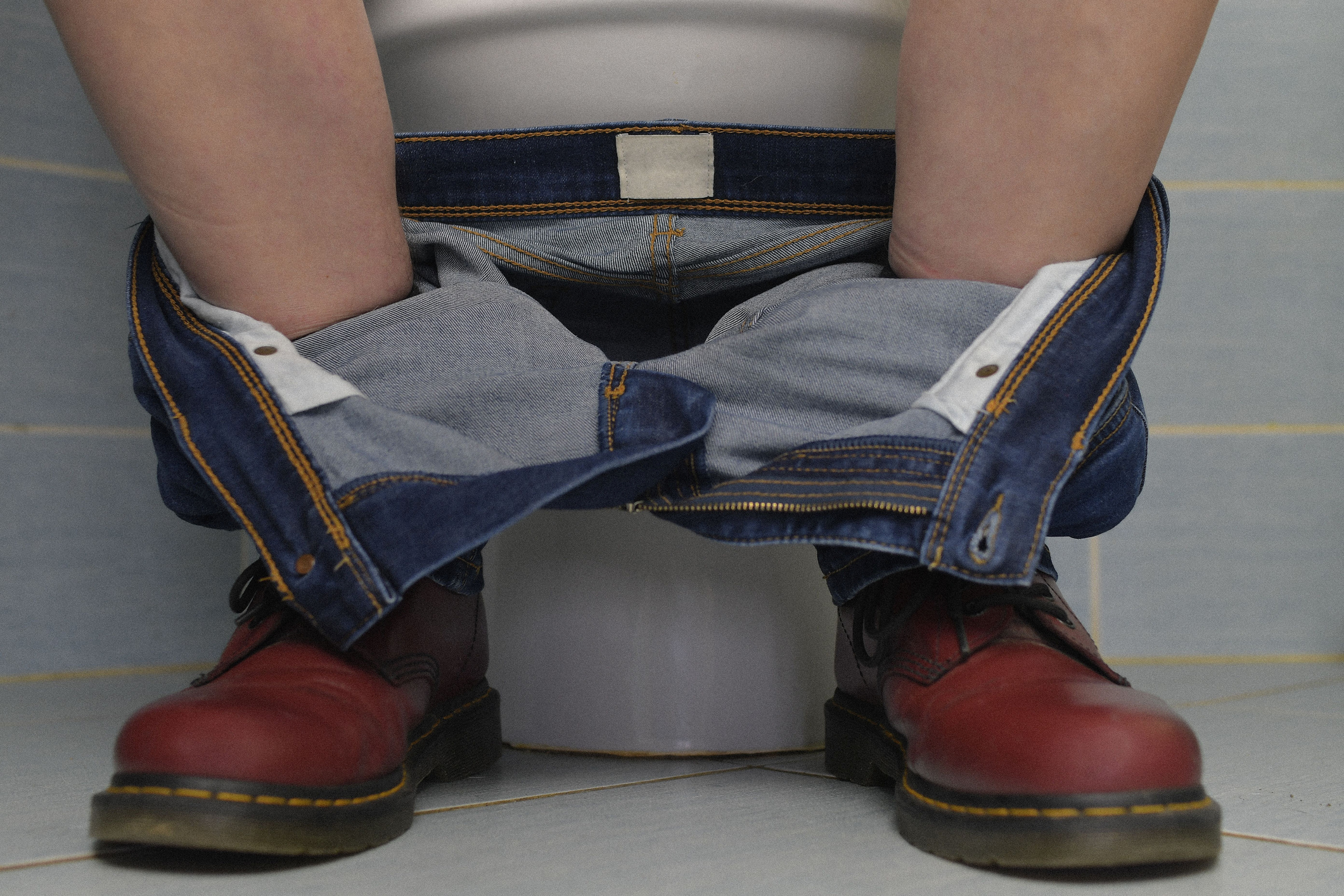 A man sitting on the toilet.