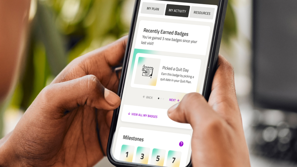 A woman is inputting information into her cell phone on the My Life My Quit app.